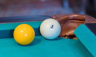 groene biljarttafel met witte ballen. bal bij de hole. detailopname foto