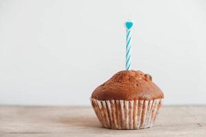 chocolade cupcake met kaars op houten tafel foto