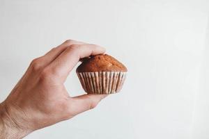 chocolade cupcake in de hand op een witte achtergrond foto