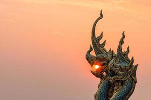 mooi standbeeld bij tempel sirindhorn wararam phuproud in de provincie ubon ratchathani met avondrood, thailand.the openbare tempel van het boeddhisme foto