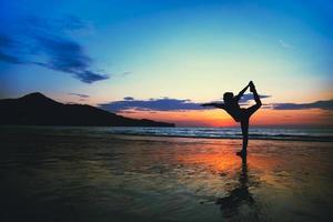 jonge vrouw yoga op het strand gelukkig oefening zomer. foto