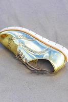 gouden schoen strandde aangespoelde afvalvervuiling op het strand van brazilië. foto