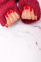 rode matte manicure op dameshanden in trui voor Valentijnsdag verticaal formaat met kopieerruimte foto