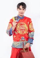 man draagt een cheongsam-pak en haalt veel dingen uit het gebruik van een creditcard in het chinees nieuwjaar foto