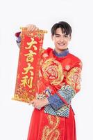 man draagt cheongsam-pak geef familie de chinese wenskaart voor geluk in chinees nieuwjaar foto
