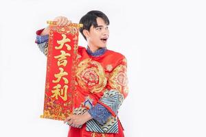 man draagt cheongsam-pak geef familie de chinese wenskaart voor geluk in chinees nieuwjaar foto
