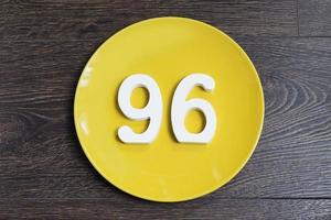 het getal zesennegentig op een gele plaat. foto