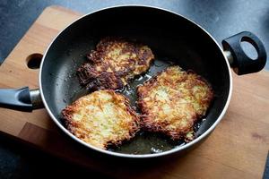 Aardappelpannenkoekjes gebakken in een pan. avondeten klaarmaken. foto