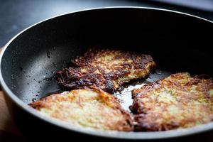 Aardappelpannenkoekjes gebakken in een pan. avondeten klaarmaken. foto