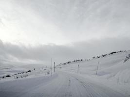 rijden door besneeuwde weg en landschap in noorwegen. foto