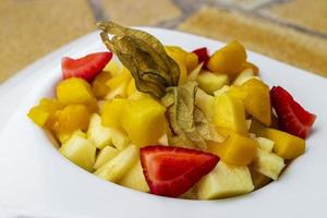 bord fruitsalade met physalis ananas aardbeien. foto