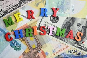 het woord vrolijk kerstfeest op de bankbiljetten als achtergrond. foto