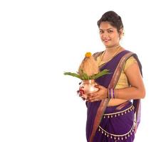 Indiase traditionele vrouw met een traditionele koperen kalash, indisch festival, koperen kalash met kokosnoot en mangoblad met bloemendecoratie, essentieel in hindoe puja. foto