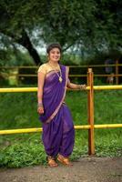 mooi Indisch jong meisje in traditionele saree die buitenshuis poseert foto