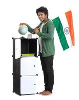 jonge man met Indiase vlag of driekleur met wereldbol op witte achtergrond, indische onafhankelijkheidsdag, indische republiek dag foto