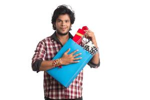 jonge mannen tonen rakhi op zijn hand met boodschappentassen en geschenkdoos ter gelegenheid van raksha bandhan festival. foto