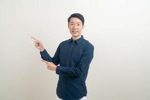 Aziatische man met hand wijzend of presenteren op witte achtergrond foto