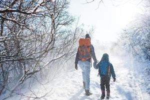 vrouw met een kind op een winterwandeling in de bergen. foto