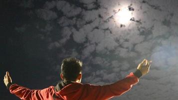 achteraanzicht van een man tegen een prachtige nachtelijke hemel op de achtergrond. het concept van vrijheid van meningsuiting foto
