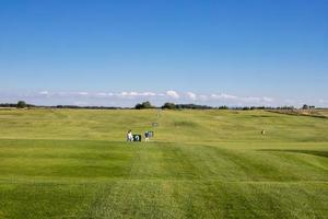 golfbaan uitzicht op een zonnige dag blauwe lucht golf concept foto