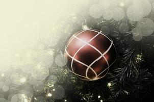 close-up van rode kerstbal die aan een versierde kerstboom hangt. retro filtereffect. foto