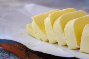 close-up van een plakje boter op een snijplank