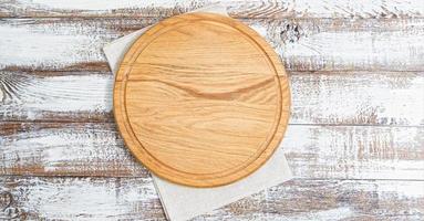 servet en bord voor pizza op houten bureau close-up, tafelkleed. canvas, theedoeken op witte houten tafel achtergrond bovenaanzicht mock up. selectieve focus foto
