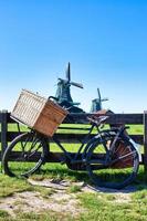 fiets met windmolen en blauwe hemelachtergrond. schilderachtig landschap in de buurt van amsterdam in nederland. foto