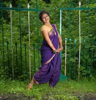 mooi Indisch jong meisje in traditionele saree die buitenshuis poseert foto