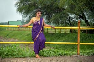 mooi Indisch jong meisje in traditionele saree die buitenshuis poseert foto