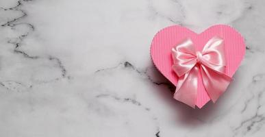 roze geschenkdoos hartvorm op marmeren bacground met kopie ruimte banner formaat foto