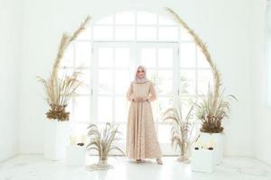 full body portret van dame gebruik een trouwjurk, bruiloft make-up op hijab. maleis of indonesië trouwjurk, beauty of eidul fitri concept. mooie Zuidoost-Aziatische moslimvrouw poseren in islamitische jurk foto