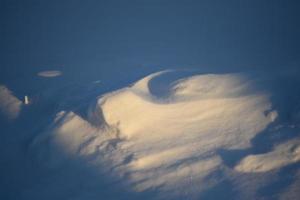 besneeuwde landschappen en sneeuw close-up in zonnestralen. gras en voorwerpen in de sneeuw. foto