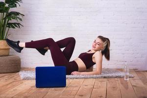 girlblogger in het interieur doet aan fitness en demonstreert via internet foto