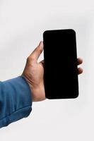 smartphone in de hand houden op witte achtergrond foto