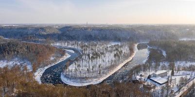 luchtfoto van een blauwe en groene rivier met sneeuw en gemalen ijs tijdens een ijsafwijking in de winter foto