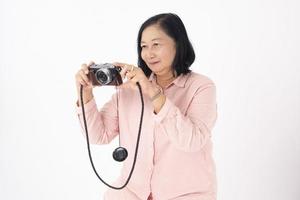 Aziatische oudere vrouw op witte achtergrond, reisconcept foto