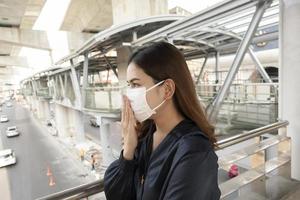 mooie vrouw die een antistofmasker draagt, beschermt luchtvervuiling en pm 2.5 op straatstad