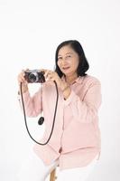 Aziatische oudere vrouw op witte achtergrond, reisconcept foto