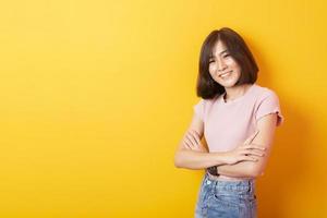 mooie Aziatische vrouw universiteitsstudent gelukkig op gele achtergrond foto