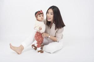 Aziatische moeder en schattig babymeisje zijn blij op een witte achtergrond foto
