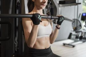 mooie aziatische vrouw doet oefening in de sportschool foto