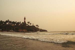 vuurtoren op het strand bij ochtend dramatische hemel in kovalam, kerala, india. kopiëren, lege ruimte voor tekst foto
