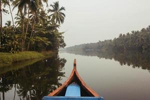houten boot op de opstuwing grachten op een achtergrond van tropisch bos met palmbomen. kopiëren, lege ruimte voor tekst foto