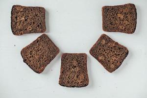 sneetjes vers bruin brood met rozijnen op een witte houten achtergrond foto