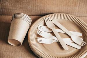 houten vorken en papieren bekers met borden op kraftpapier achtergrond foto