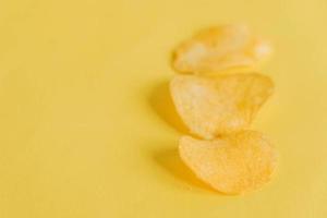 drie chips op een gele achtergrond foto