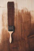 borstel met houten handvat en natuurlijke haren tegen de achtergrond van geverfde bruine houten planken foto