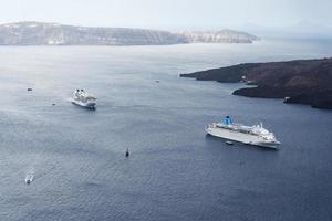 prachtig landschap met uitzicht op zee. cruiseschip in zee bij nea kameni, een klein grieks eiland in de egeïsche zee bij santorini. foto