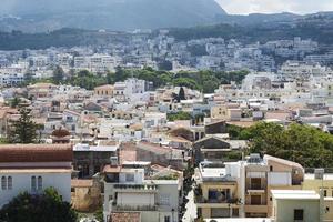 uitzicht op resort Griekse architectuur rethymno stad-poort, gebouwd door Venetianen, vanaf de hoogte van fortezza kasteel - fort op de heuvel paleokastro. rode pannendaken en bergen op de achtergrond. Kreta. foto